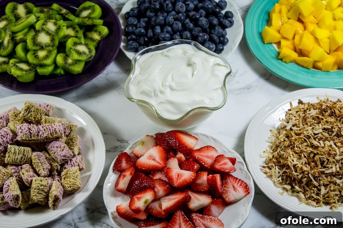 Vibrant Seven Layer Fruit Stack 7 Fresh ingredients for 7 layer fruit salad including berries, kiwi, mango, coconut flakes, Greek yogurt, and Post cereal.