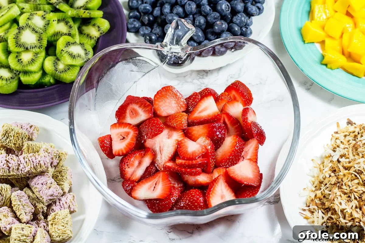 The first layer of the 7-layer fruit salad, featuring a vibrant base of chopped strawberries.