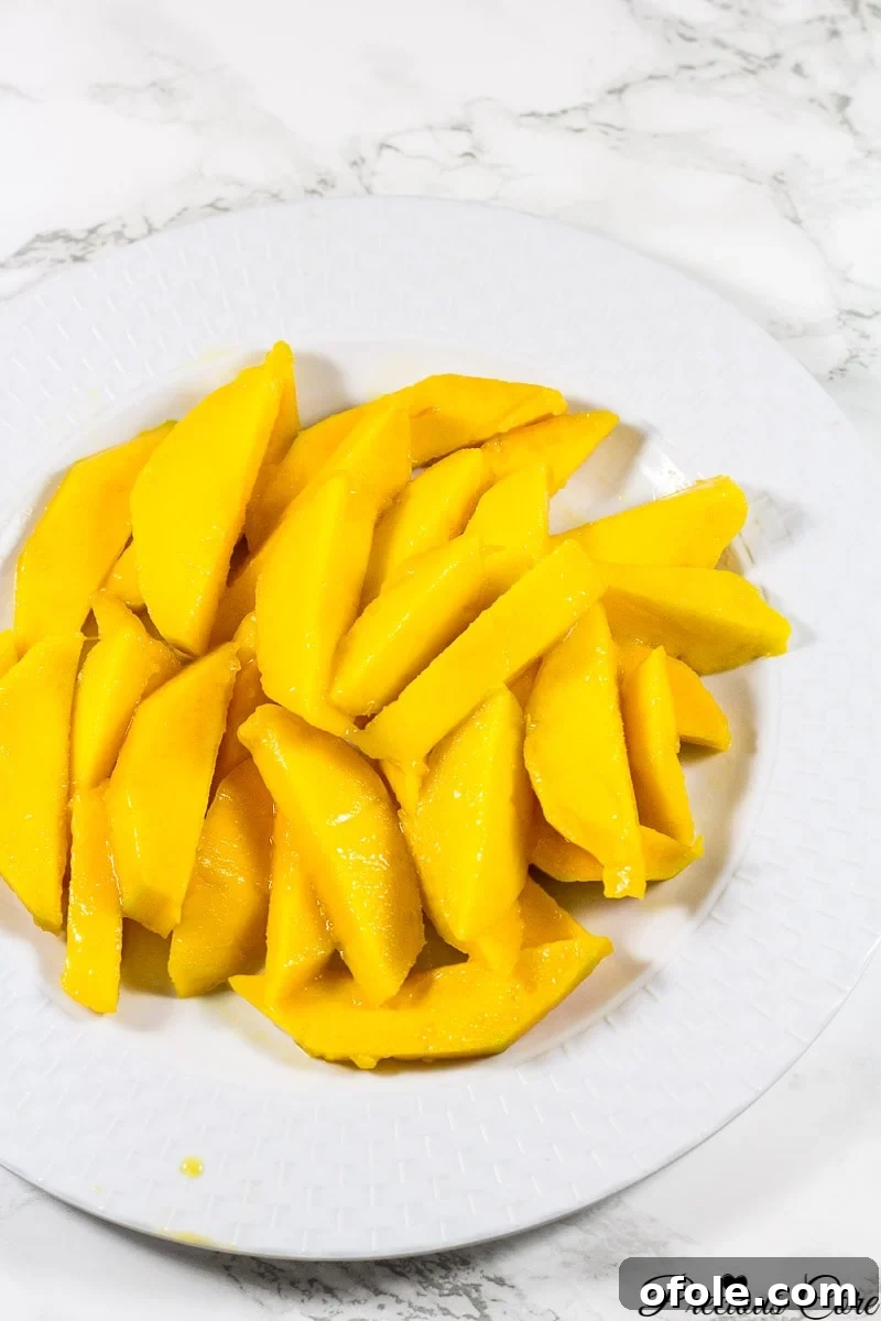 Caramelized Mango Flip-Over Cake 3 Fresh mango slices arranged artfully on a white plate