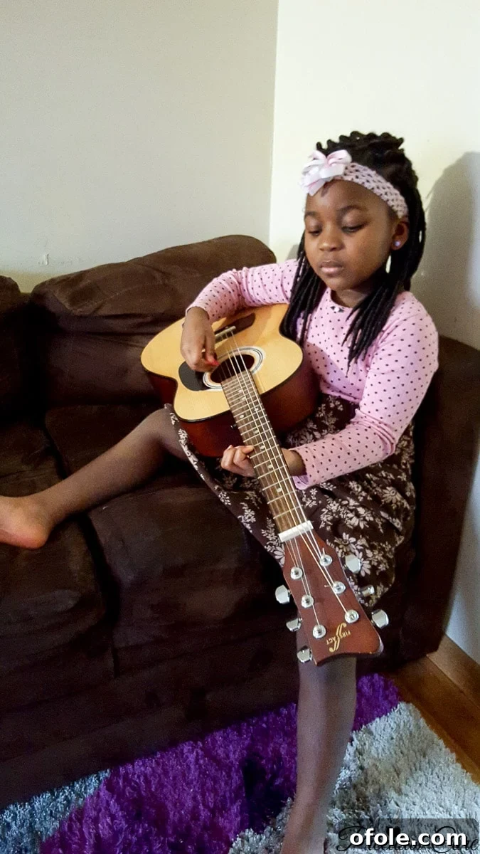 The First Chapter Of Our Homeschool Story 7 Neriah diligently practicing her guitar, embracing music education as part of homeschooling