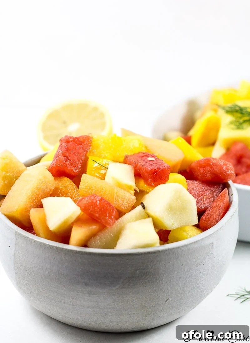 Vibrant Cameroonian Fruit Salad How To 3 A close-up shot of a bowl filled with colorful fruit salad, highlighting juicy pieces of watermelon, bright orange mango, and other tropical fruits.