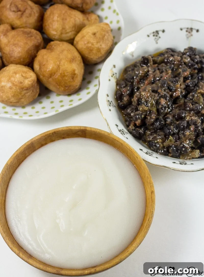 Freshly prepared bowl of fermented corn porridge (Pap, Akamu, Ogi) with a spoon, ready to be enjoyed.