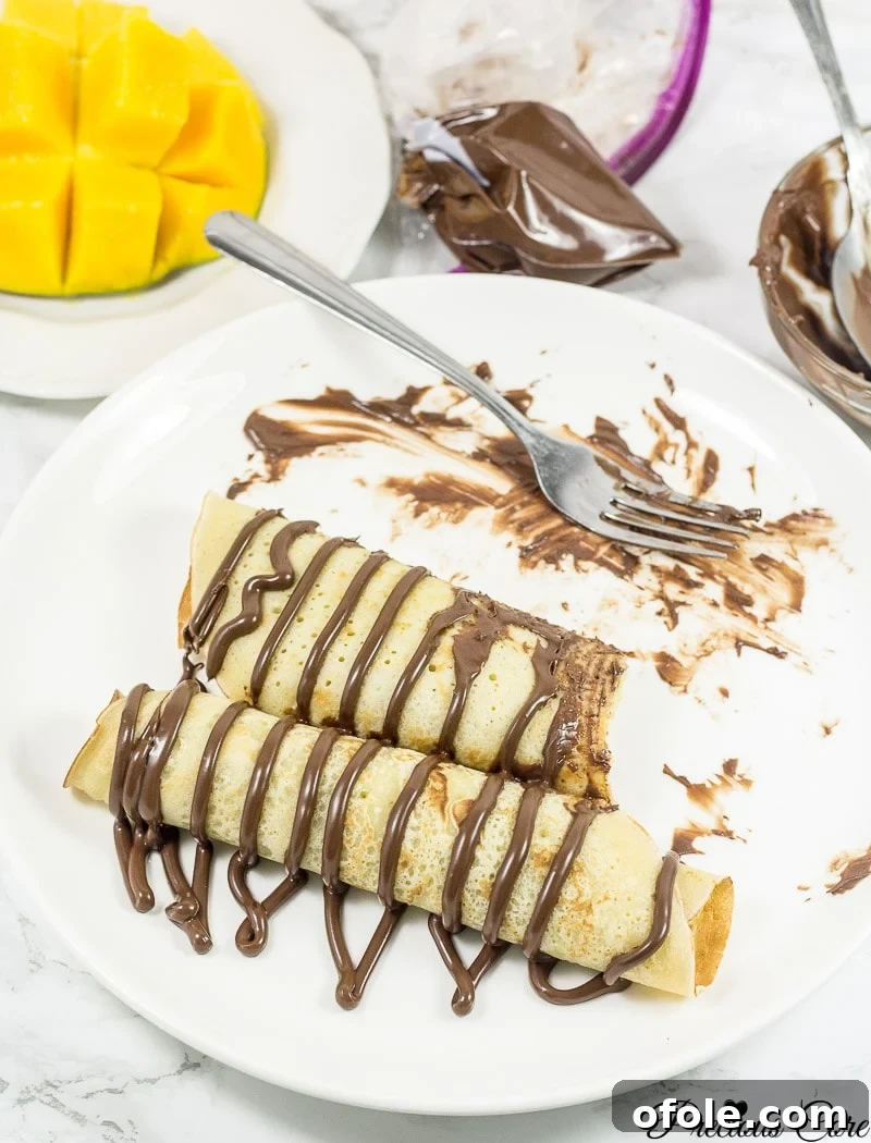 Cameroon's Delightful Savory Pancakes 2 Cameroonian pancakes drizzled with chocolate.