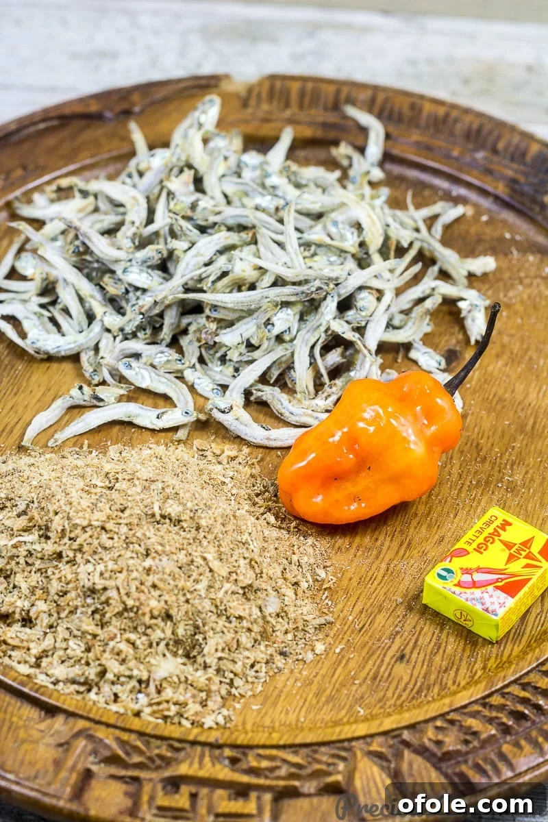 Mboh Groundnut Paste 5 A selection of fresh and dried ingredients for making Cameroonian Mboh, including peanuts, ground crayfish, hot pepper, seasoning cubes, salt, and optional dried anchovies.