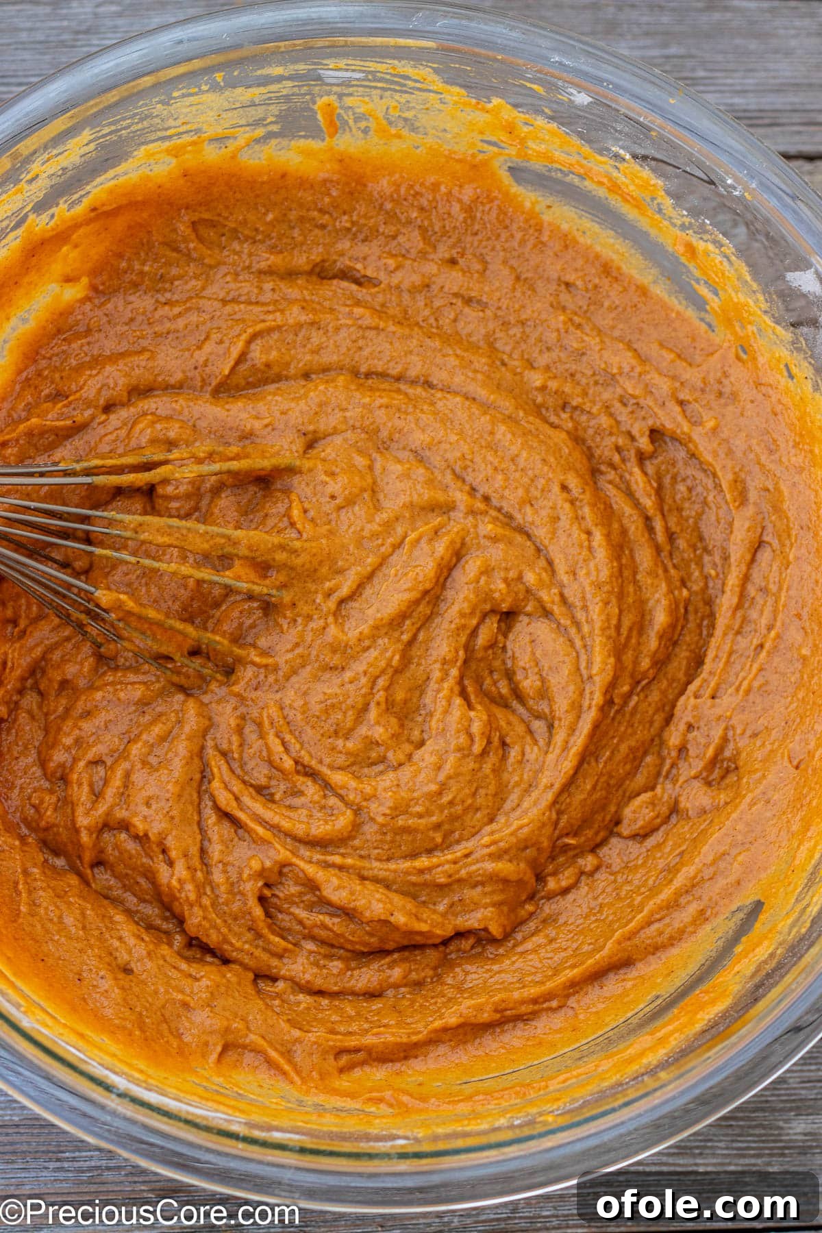 Spiced Pumpkin Cake with Luscious Cream Cheese Frosting 3 Close-up of smooth, orange-hued pumpkin cake batter in a mixing bowl, ready for baking.
