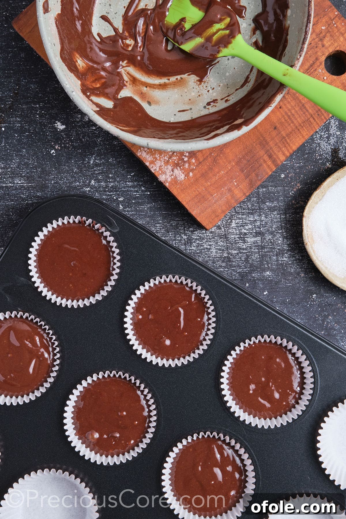 Decadent Double Chocolate Cupcakes 12 Chocolate cupcake batter scooped into muffin pan with liners, ready to enter the oven.