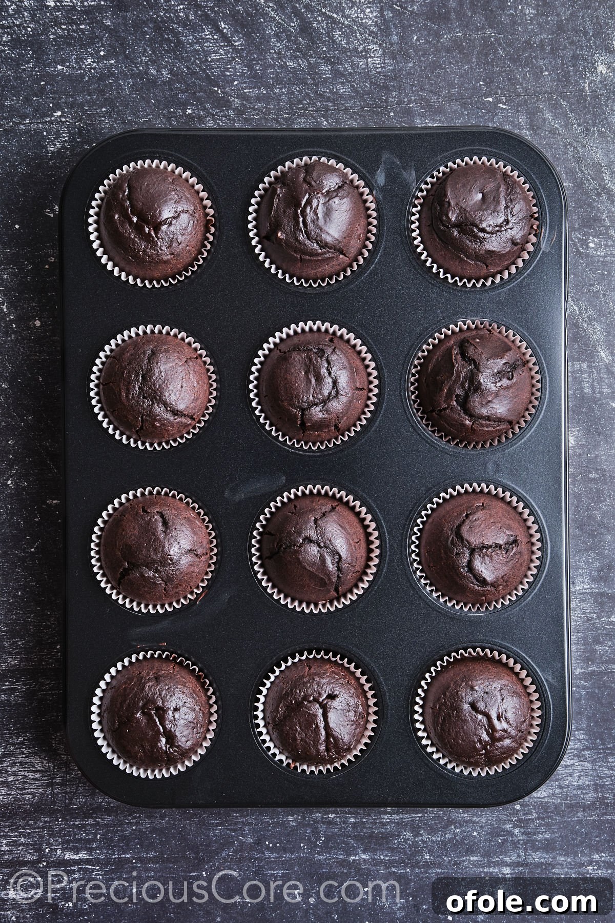 Decadent Chocolate Cupcakes 13 Freshly baked cupcakes cooling on a wire rack after being removed from the oven.