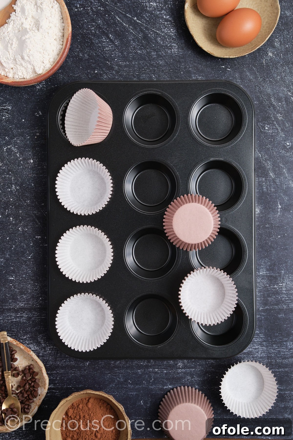Decadent Double Chocolate Cupcakes 6 A muffin pan being lined with cupcake liners, a necessary step before adding batter.