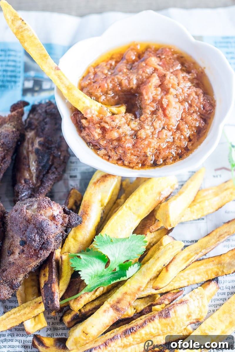 Plantain Fries 5 Baked plantain fries served with dipping sauce and crispy chicken wings, ready for a delicious meal.