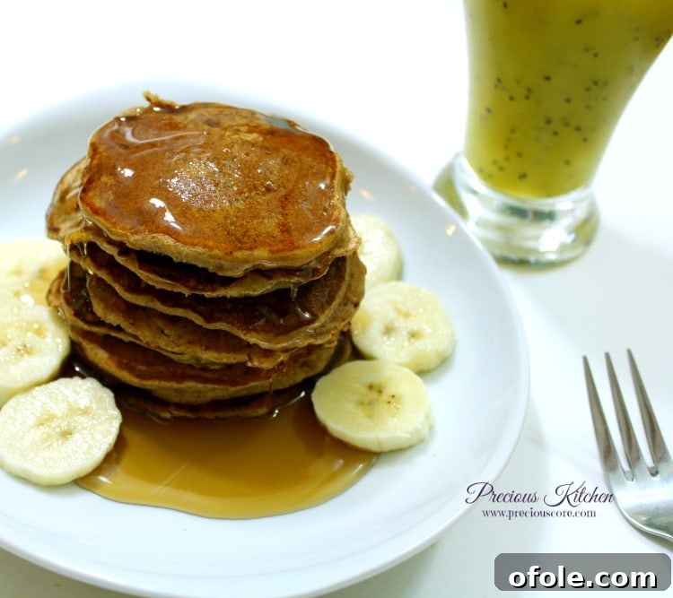 Served Banana Pancakes Stack of finished whole wheat banana pancakes with honey and smoothie