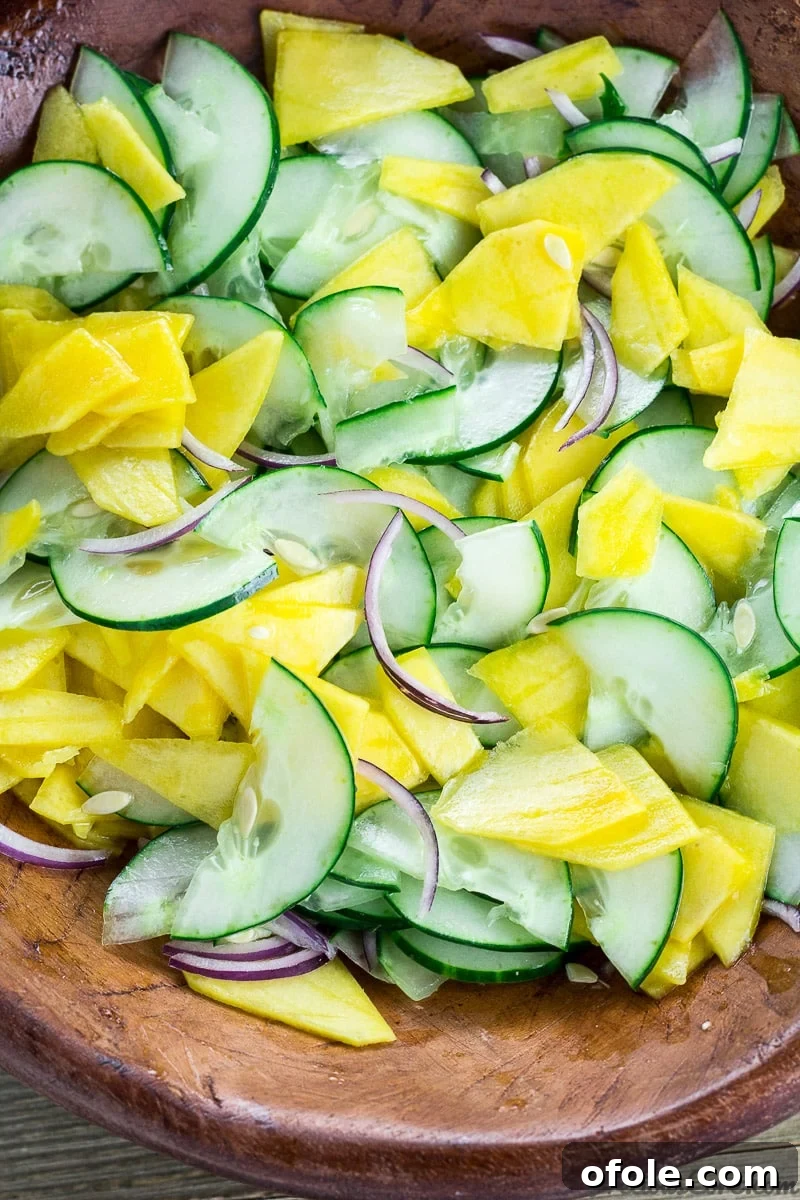 Vibrant Mango Cucumber Refresh 2 Cucumber Mango Salad tossed in a bowl, showcasing its fresh and vibrant ingredients.
