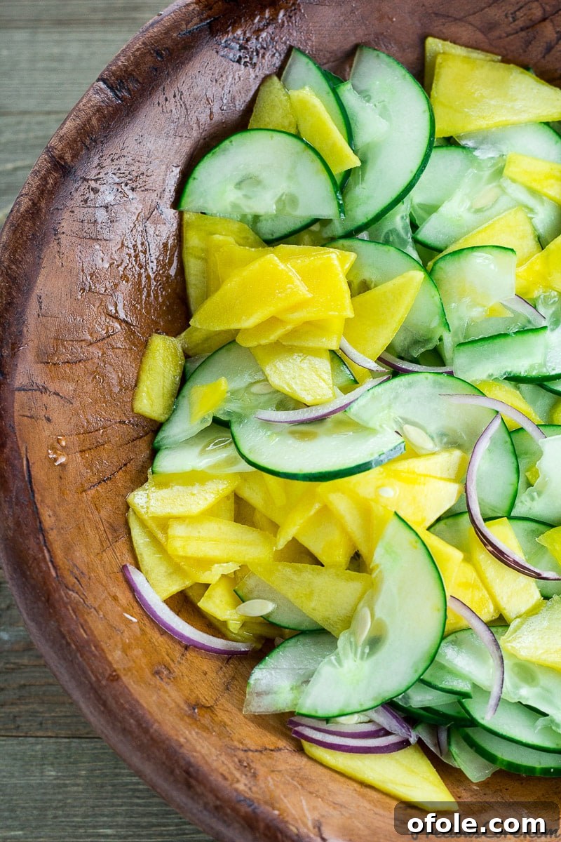 Vibrant Mango Cucumber Refresh 6 Mango cucumber salad in a rustic wooden bowl, garnished and ready to eat.