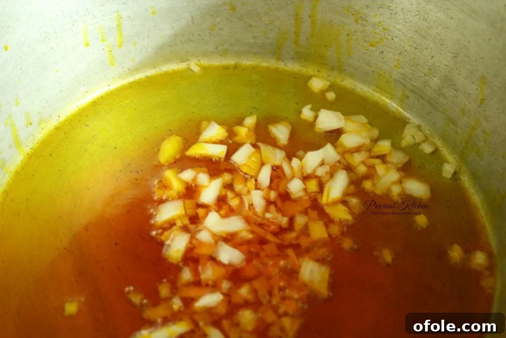 Chopped onions sizzling gently in the warm red palm oil.