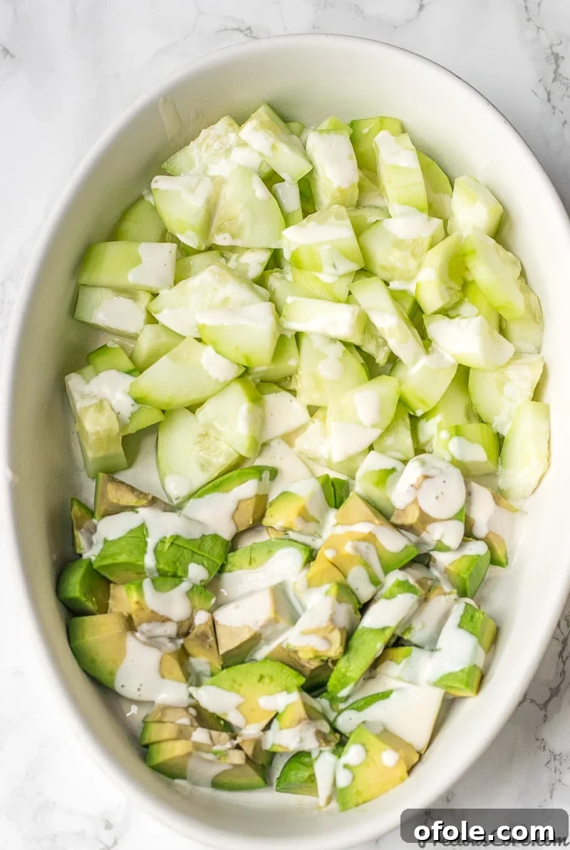 Refreshing Avocado Cucumber Salad 2 Cucumber Avocado Salad in a bowl with Mayonnaise Dressing drizzled on top