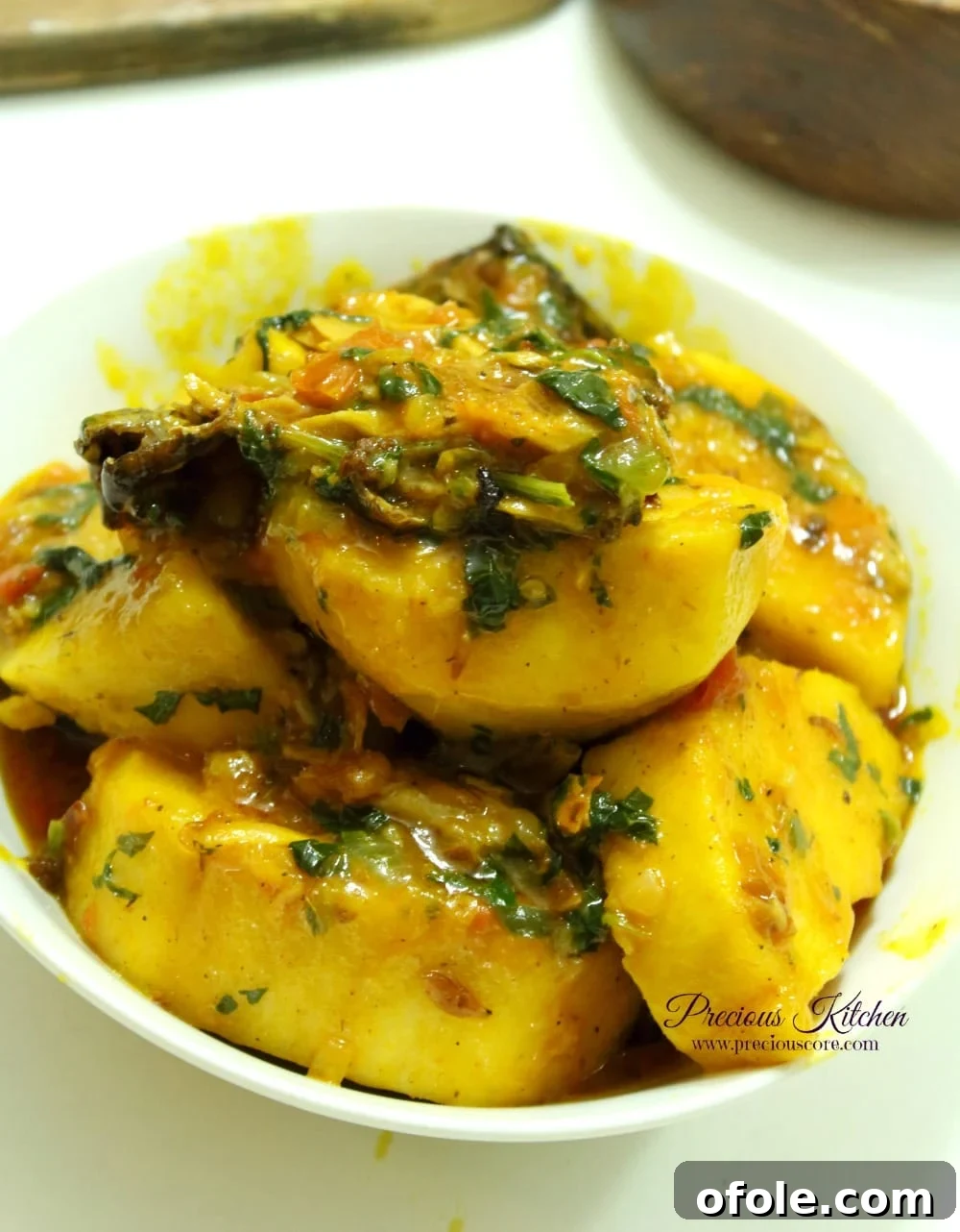 Rich and savory African Yam Porridge with fish and greens