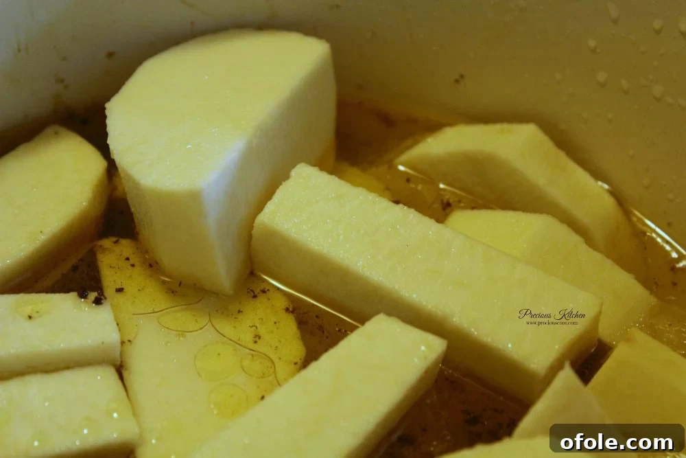 Yam pieces in a pot with water and oil, ready for ingredients