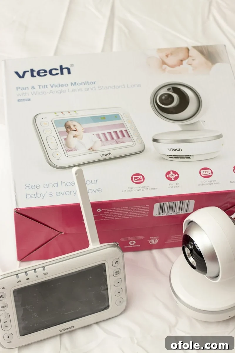 A pregnant mother preparing for her new baby by setting up a VTech baby monitor, signifying a modern approach to newborn care.