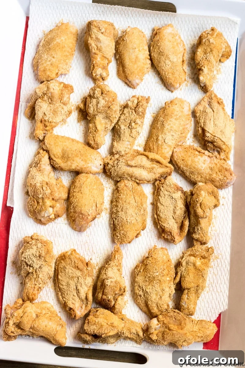 Party chicken wings generously coated with a rich, dry spice rub, highlighting the vibrant colors of the suya spice.