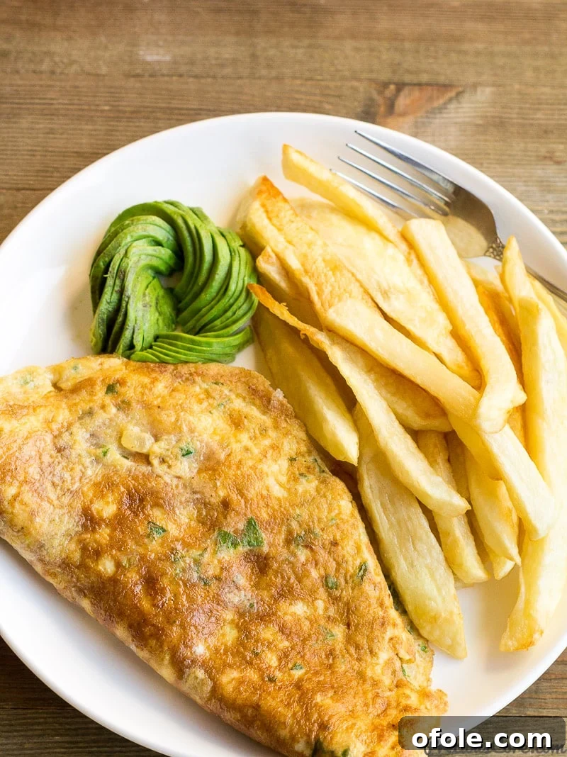 Fries and omelette for breakfast with some avocado.