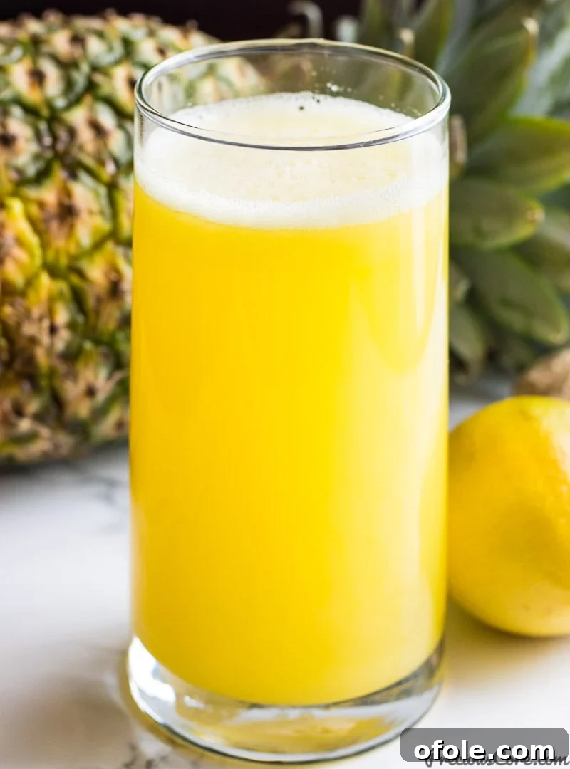 Fuel Your Day: 3 Healthy Juice Blends 3 Pineapple Ginger Juice - Close-up of golden pineapple juice in a glass with fresh pineapple slices and ginger.