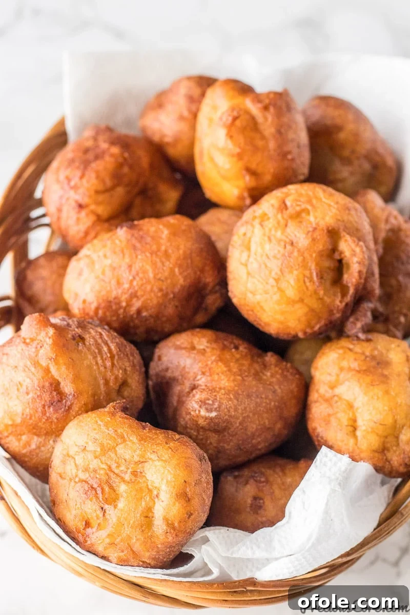 Golden Banana Bites 3 A charming basket overflowing with freshly made banana fritters, ready to be enjoyed.