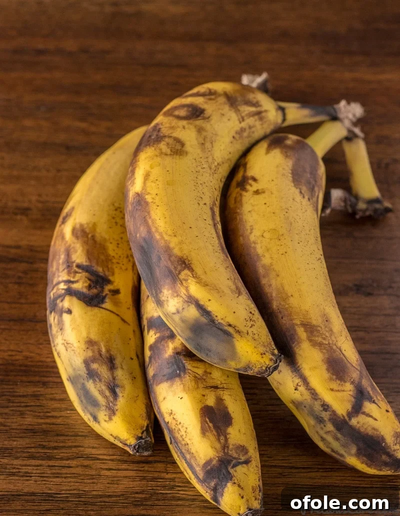 Golden Banana Bites 4 A cluster of overripe bananas displaying prominent black spots, indicating they are perfectly ready for making fritters.