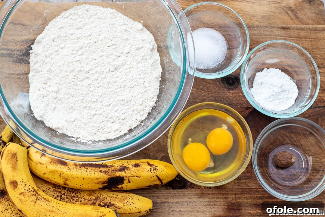 Golden Banana Bites 5 A flat lay of all the essential ingredients laid out for making banana fritters, including ripe bananas, flour, eggs, milk, and spices.