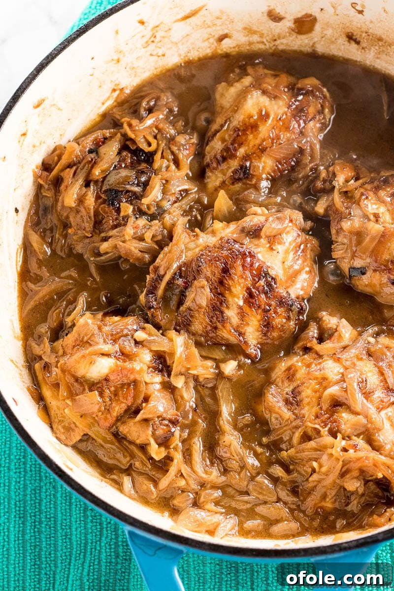 Senegalese Chicken Yassa 7 Close-up view of chicken pieces simmering with caramelized onions and marinade in a pot, illustrating the final cooking steps for Poulet Yassa.