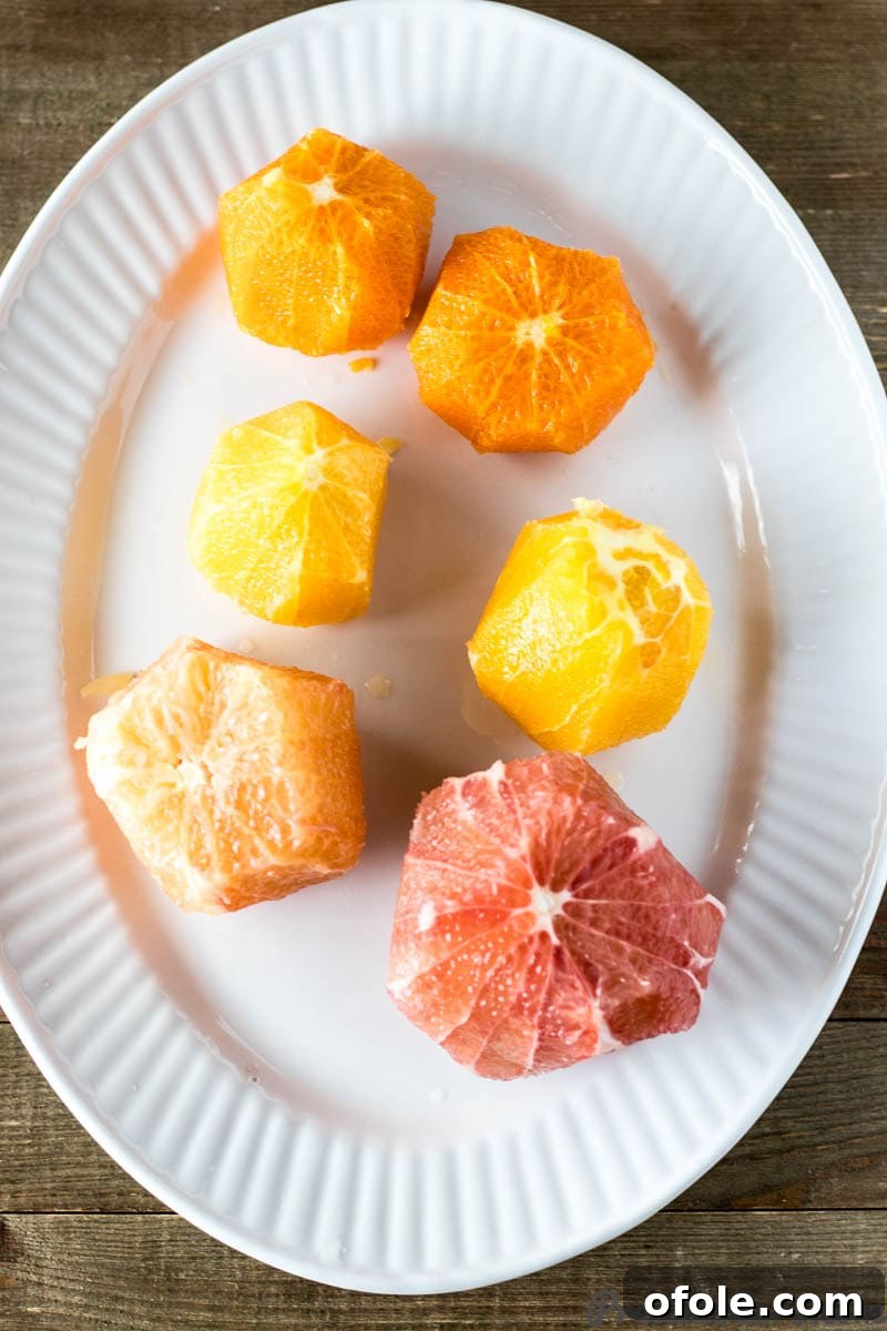 A plate showcasing neatly peeled and segmented citrus fruits, ready for assembly.