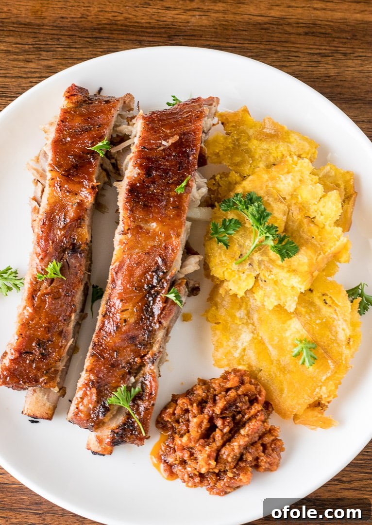 Golden Crispy Tostones The Ultimate Twice-Fried Plantain Recipe 3 Tostones on a plate with meat.