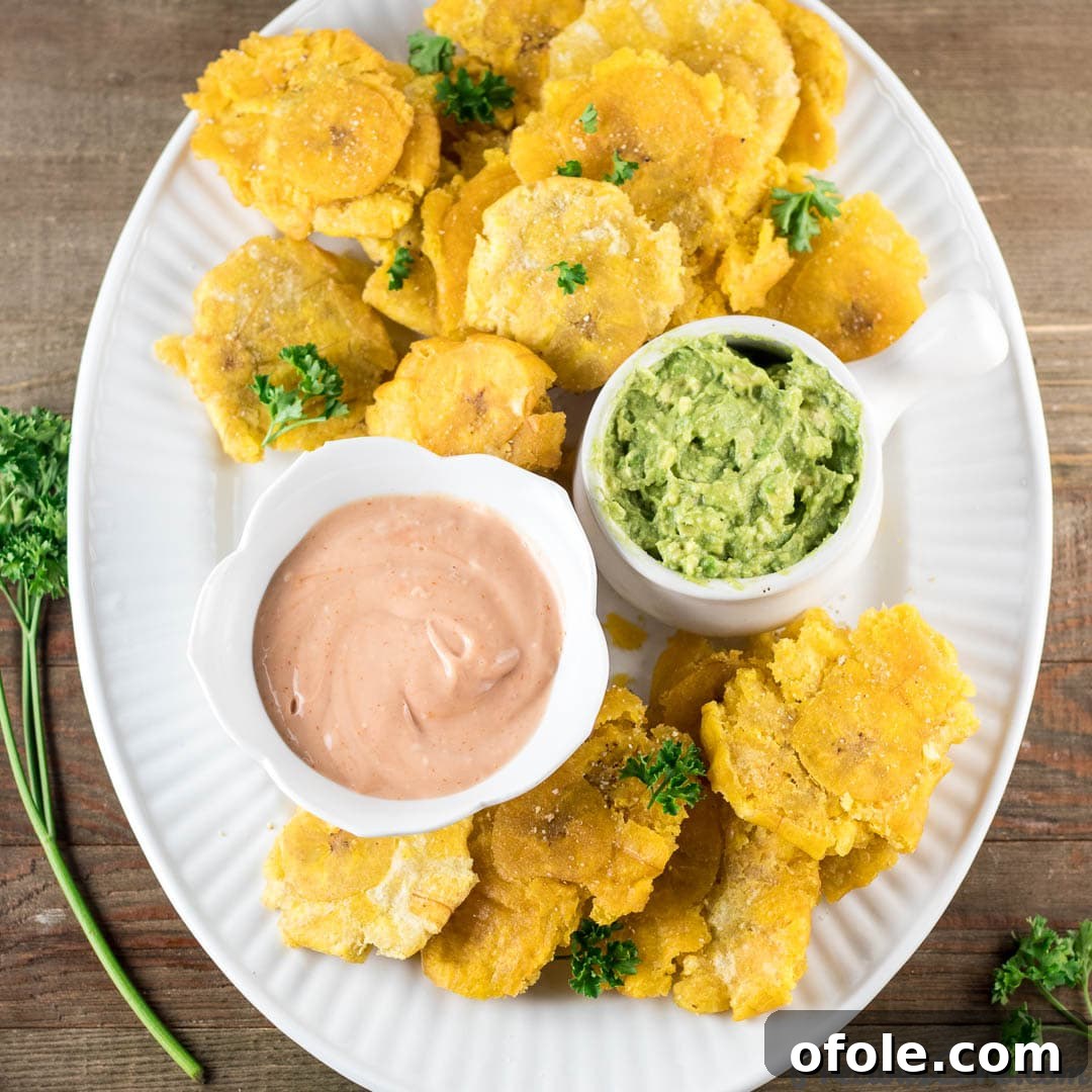 Golden Crispy Tostones The Ultimate Twice-Fried Plantain Recipe 8 Tostones on a plate with dips.