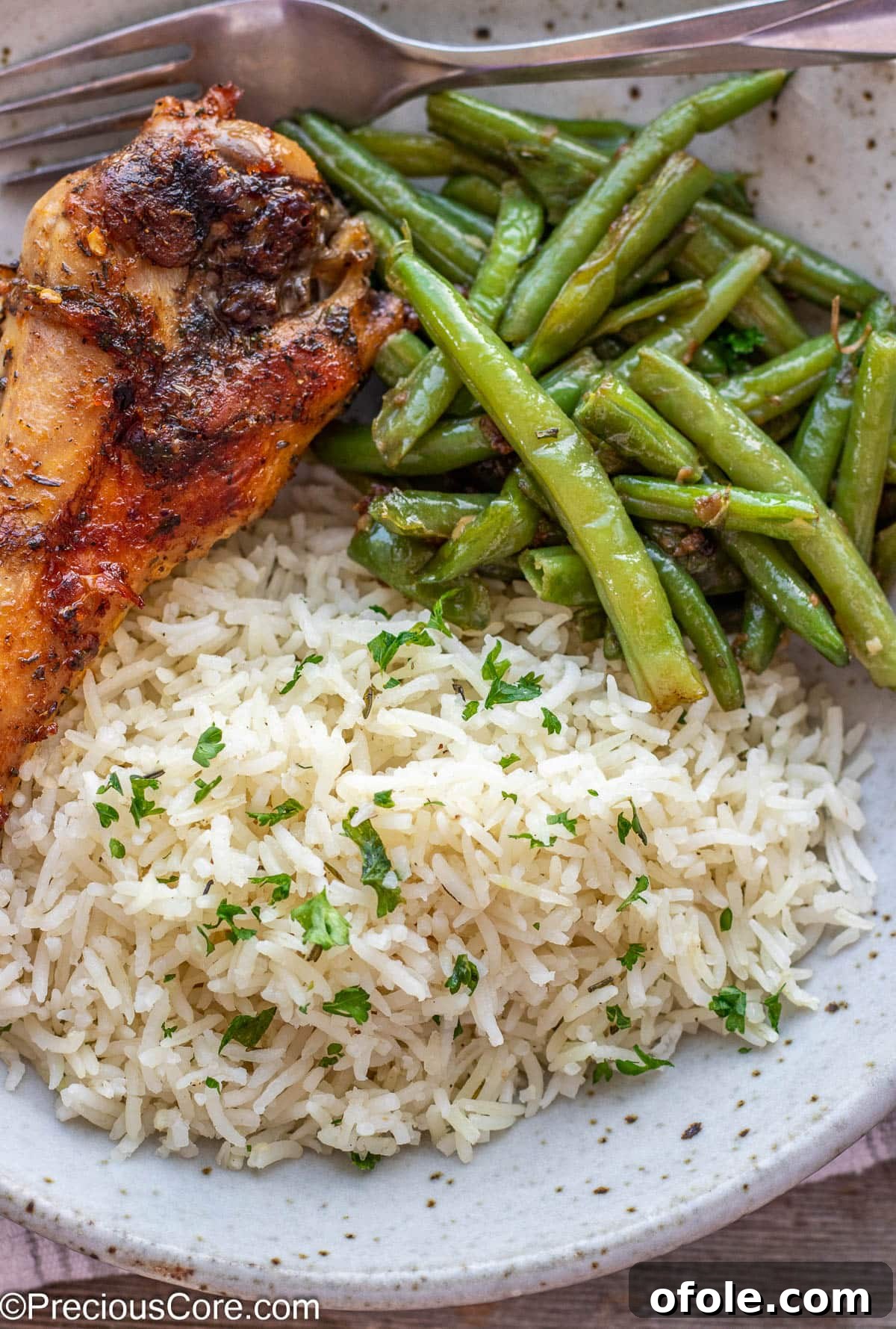 Golden Baked Turkey Wings 3 A serving of Oven Baked Turkey Wing accompanied by fluffy garlic herb rice and vibrant green beans.