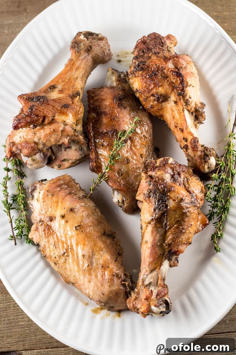 Golden Baked Turkey Wings 5 A platter brimming with freshly baked, golden-brown turkey wings, garnished with fresh herbs, ready for serving.
