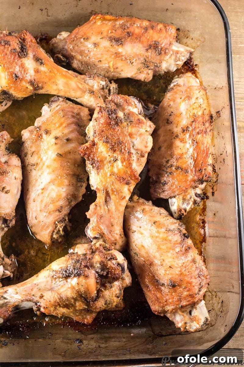 Golden Baked Turkey Wings 7 Oven Baked Turkey Wings, golden and succulent, resting in a baking dish with delicious pan drippings.