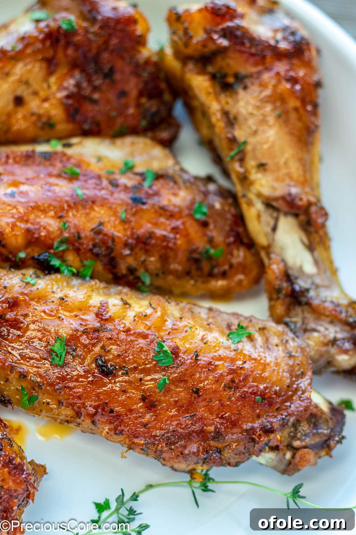 Golden Baked Turkey Wings 9 A close-up of golden-brown cooked turkey wings, garnished with freshly minced parsley, ready to be enjoyed.