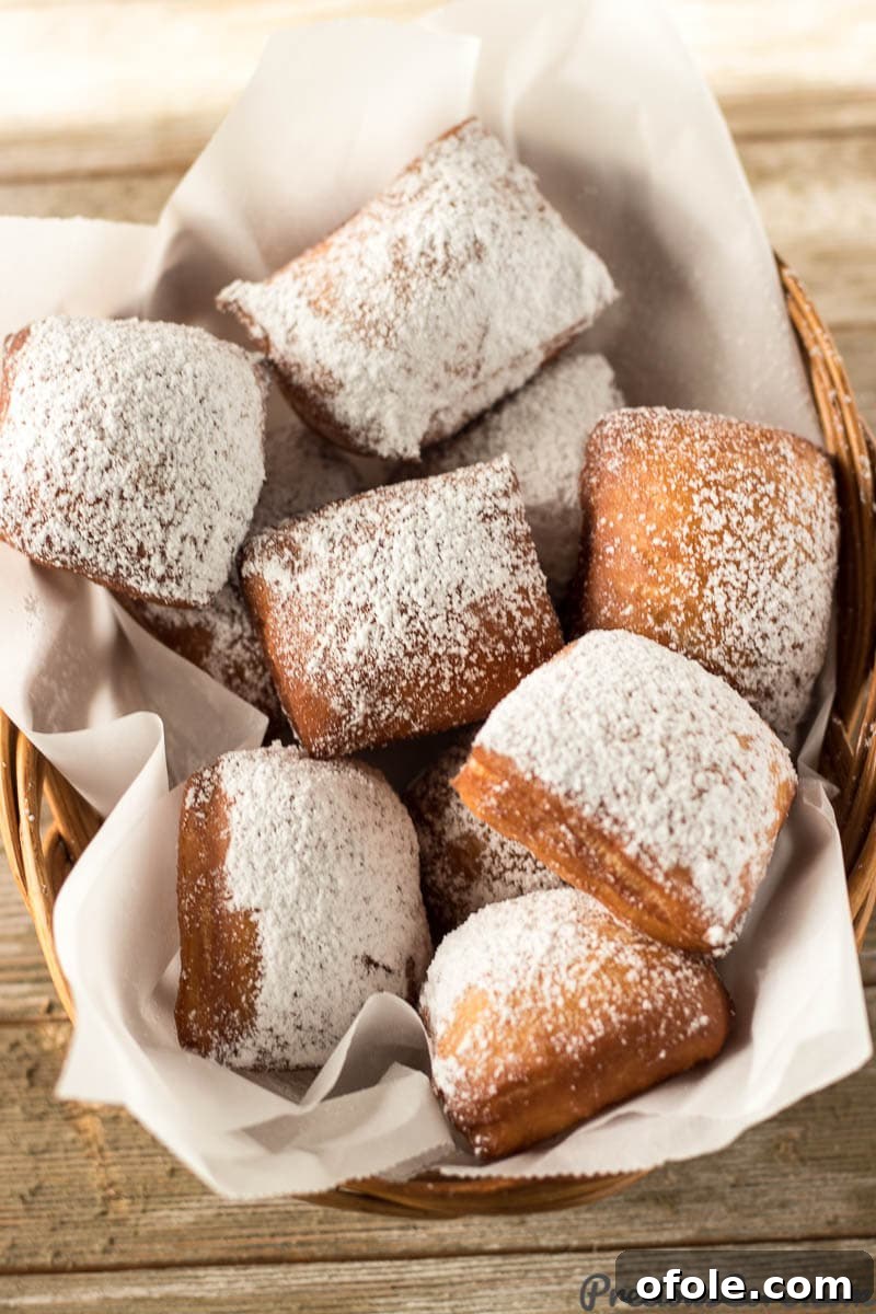 A rustic basket overflowing with freshly made, powdered sugar-dusted beignets.