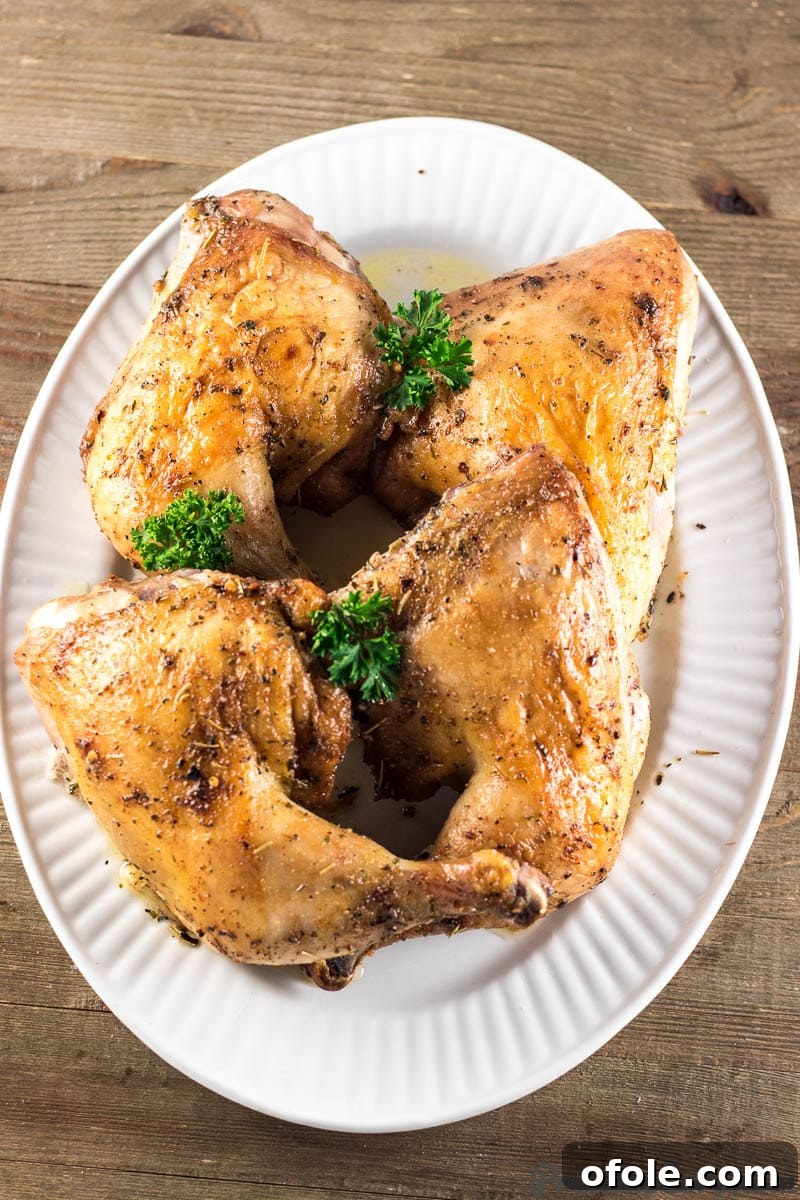 Crispy Skin Chicken Leg Quarters 2 Crispy golden-brown baked chicken leg quarters on a serving tray, glistening with juices.