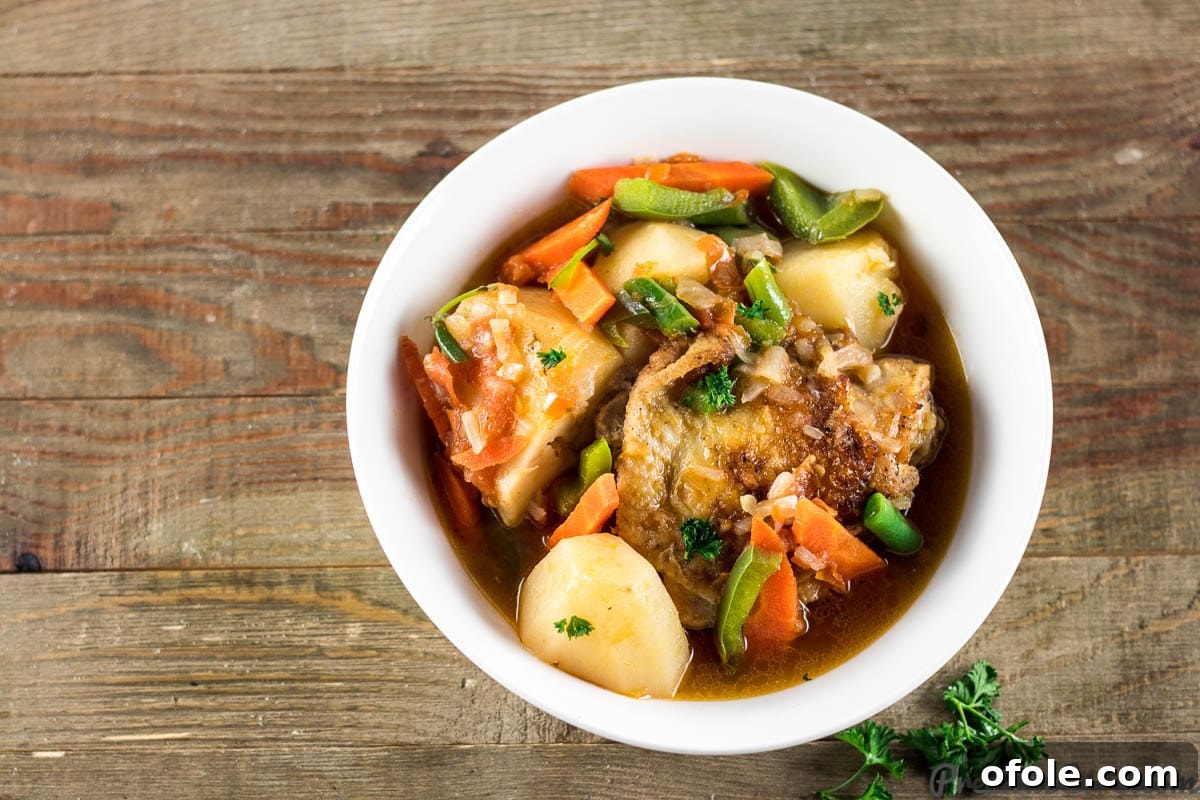Hearty Chicken and Potatoes stew served in a bowl, garnished with fresh herbs
