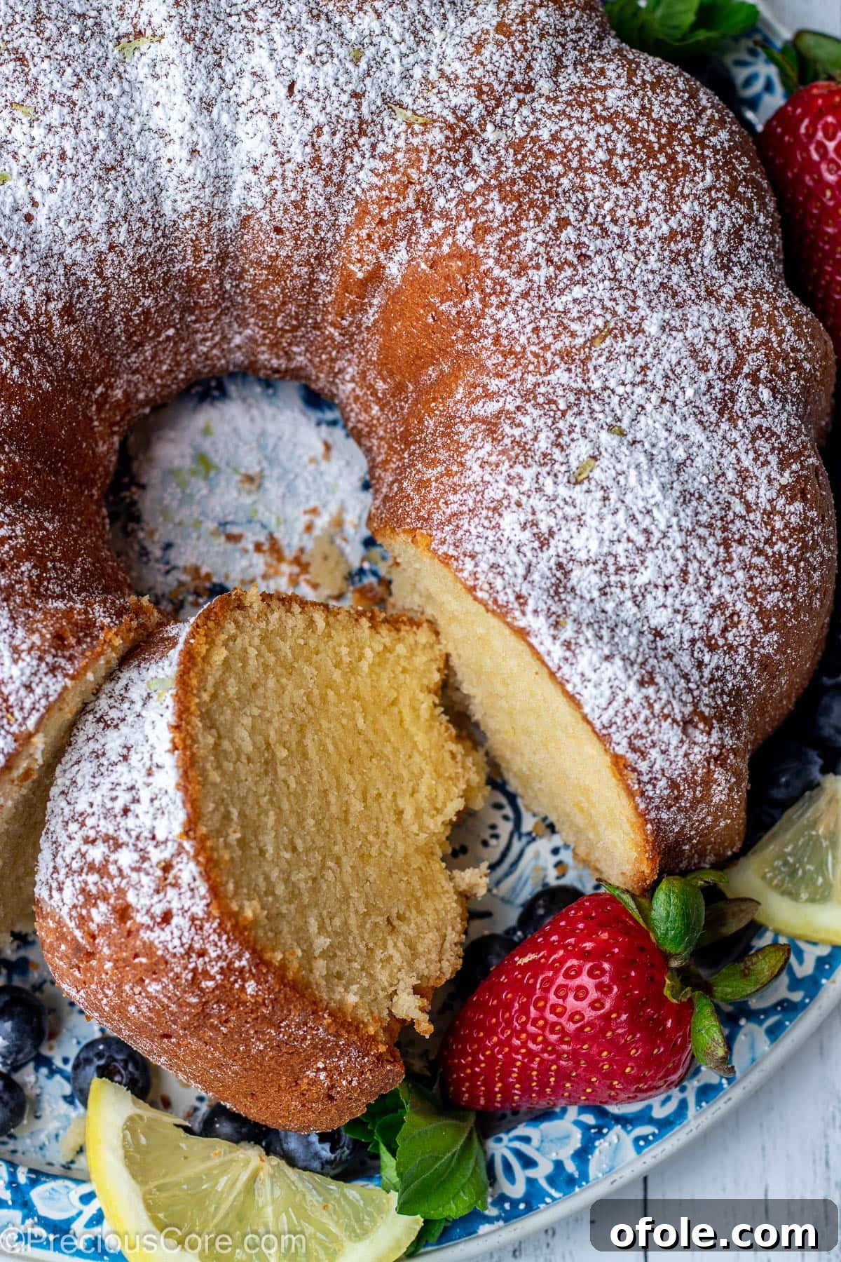 Zesty Southern Lemon Pound Cake 2 A beautifully baked lemon pound cake on a round platter, with a perfect slice cut out, ready to be served.