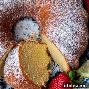 Zesty Southern Lemon Pound Cake 12 Lemon pound cake on a round platter with a piece of cake cut out.