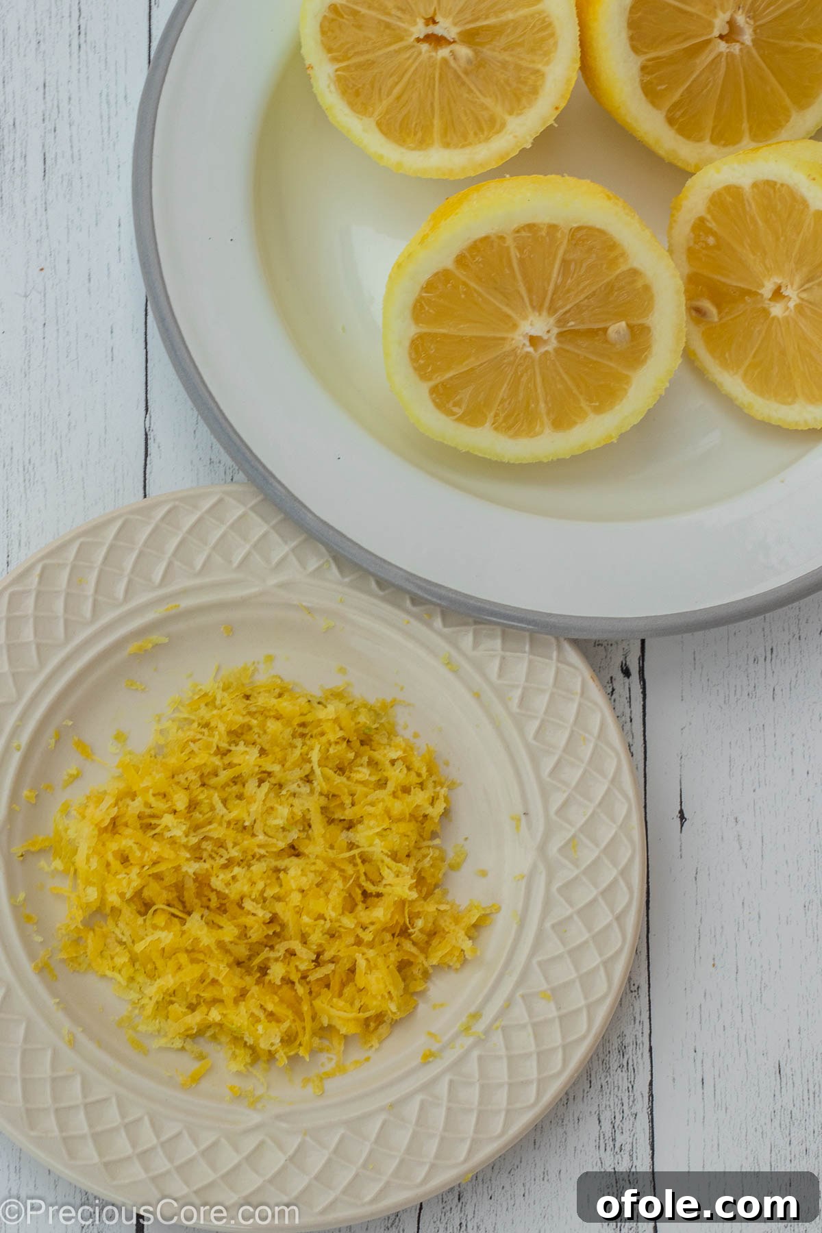 Zesty Southern Lemon Pound Cake 7 Two white plates: one with finely grated lemon zest, the other with neatly halved fresh lemons, illustrating the preparatory steps.