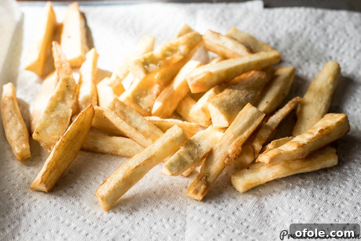 Irresistibly Crispy Yuca Fries 7 Crispy Yuca Fries resting on paper towels to absorb excess oil.