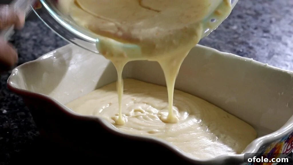 pouring batter into baking dish for South African Malva Pudding Recipe