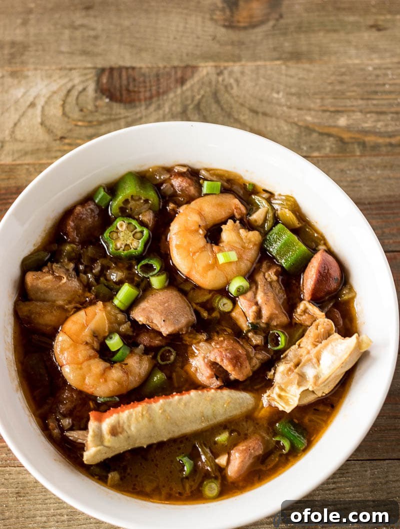 A large, rustic bowl filled with rich, authentic Seafood Gumbo, garnished with fresh herbs, ready to be served.