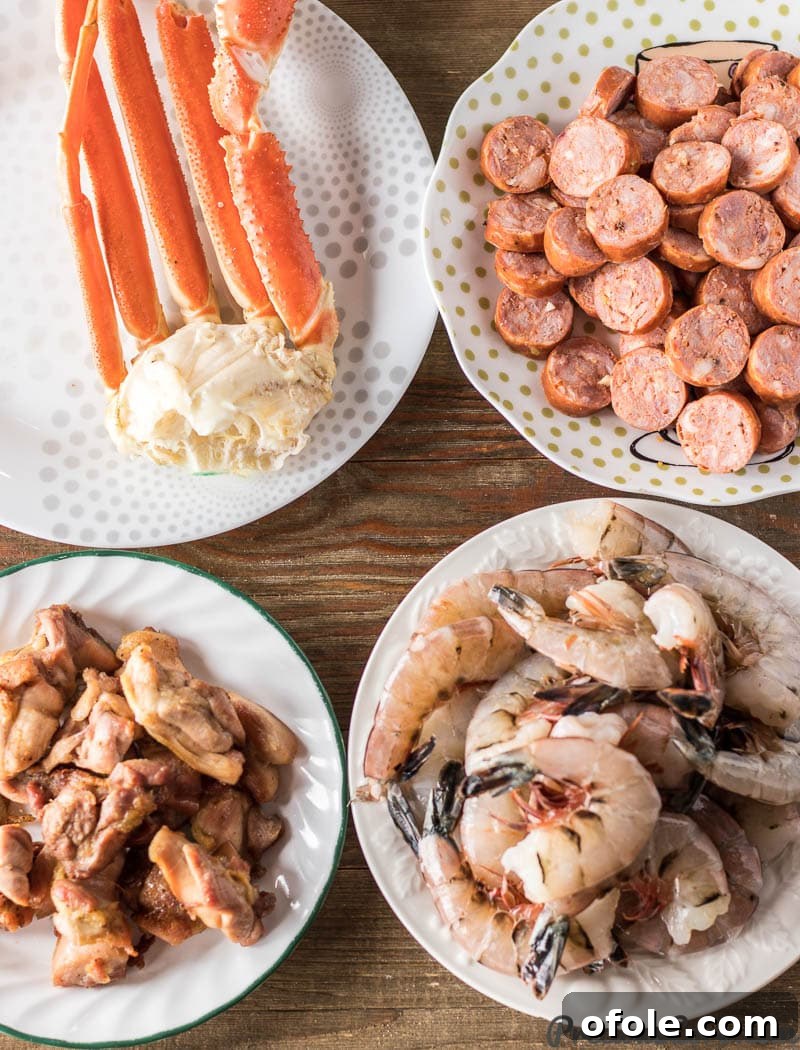 An array of premium proteins for gumbo: snow crab legs, sliced andouille sausage, perfectly baked boneless skinless chicken thighs, and large, uncooked shrimp.