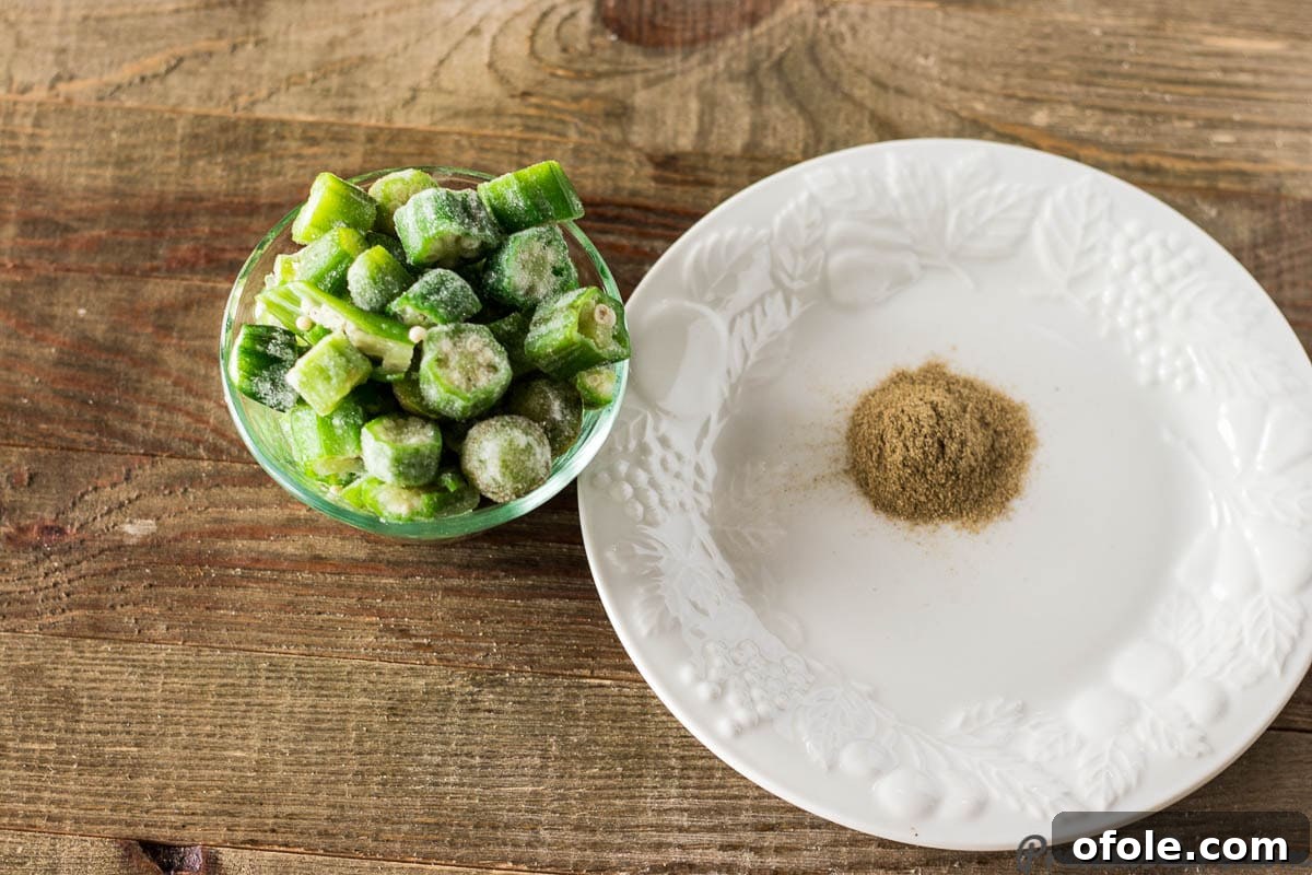A bowl of vibrant green sliced okra alongside a jar of Gumbo file powder, key thickeners and flavor enhancers for a traditional gumbo.