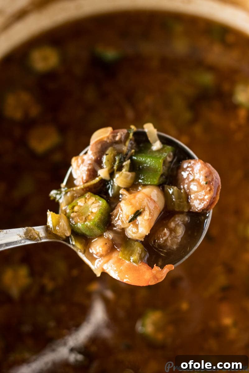 A bubbling pot of Seafood Gumbo, rich with okra, shrimp, and other ingredients, simmering to perfection.