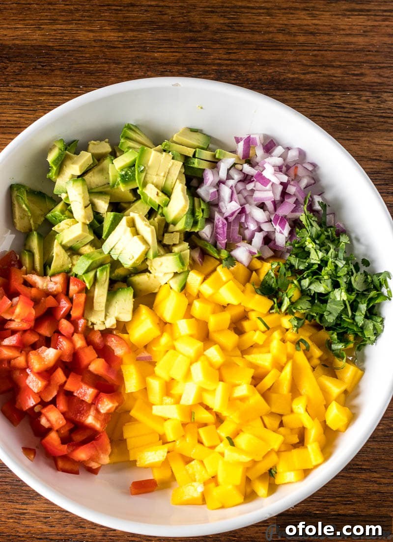 Chopped ingredients for Mango Avocado Salsa in a bowl, ready to be mixed.
