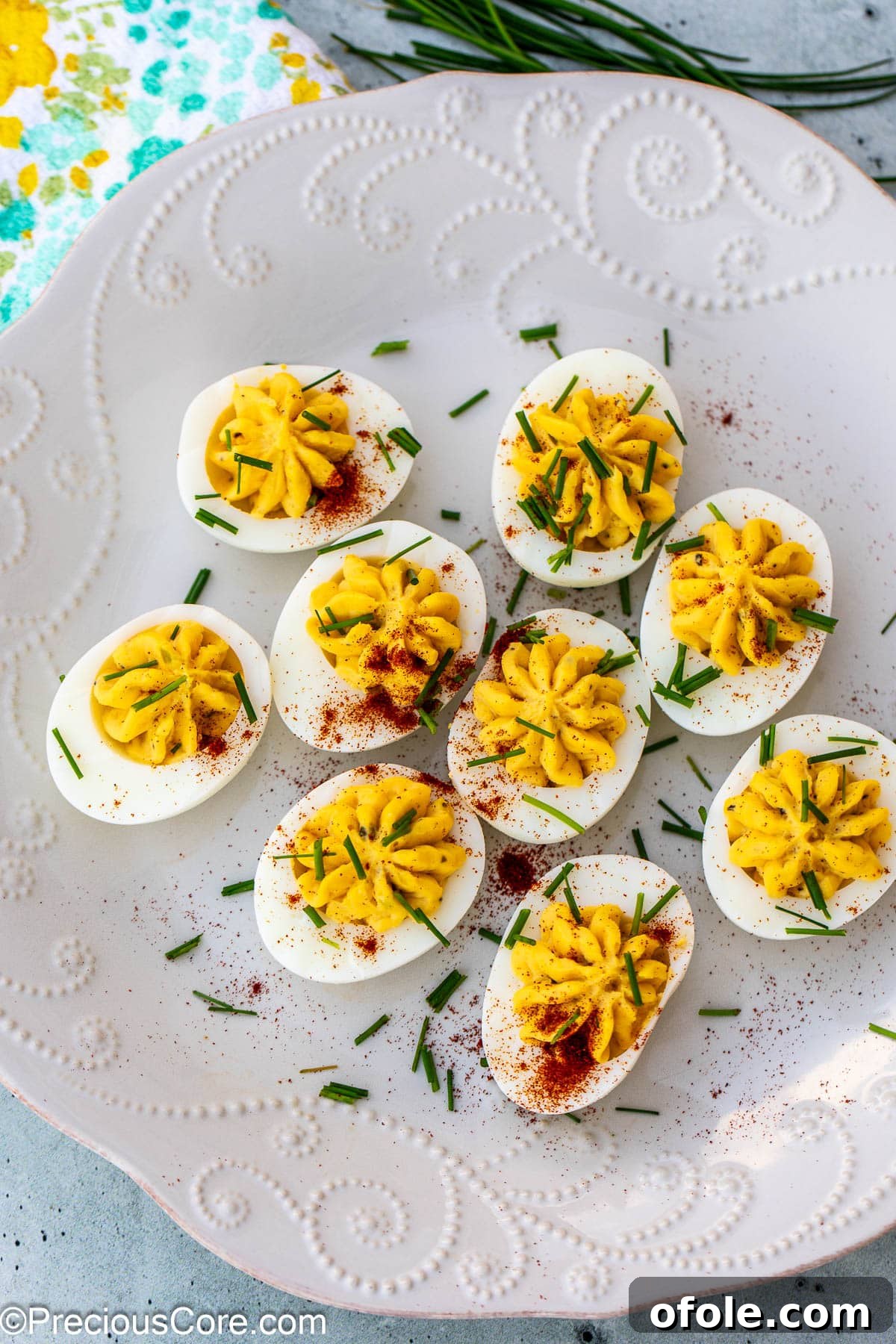 Southern Charm Deviled Eggs 2 Platter of decorated deviled eggs with paprika and chives.