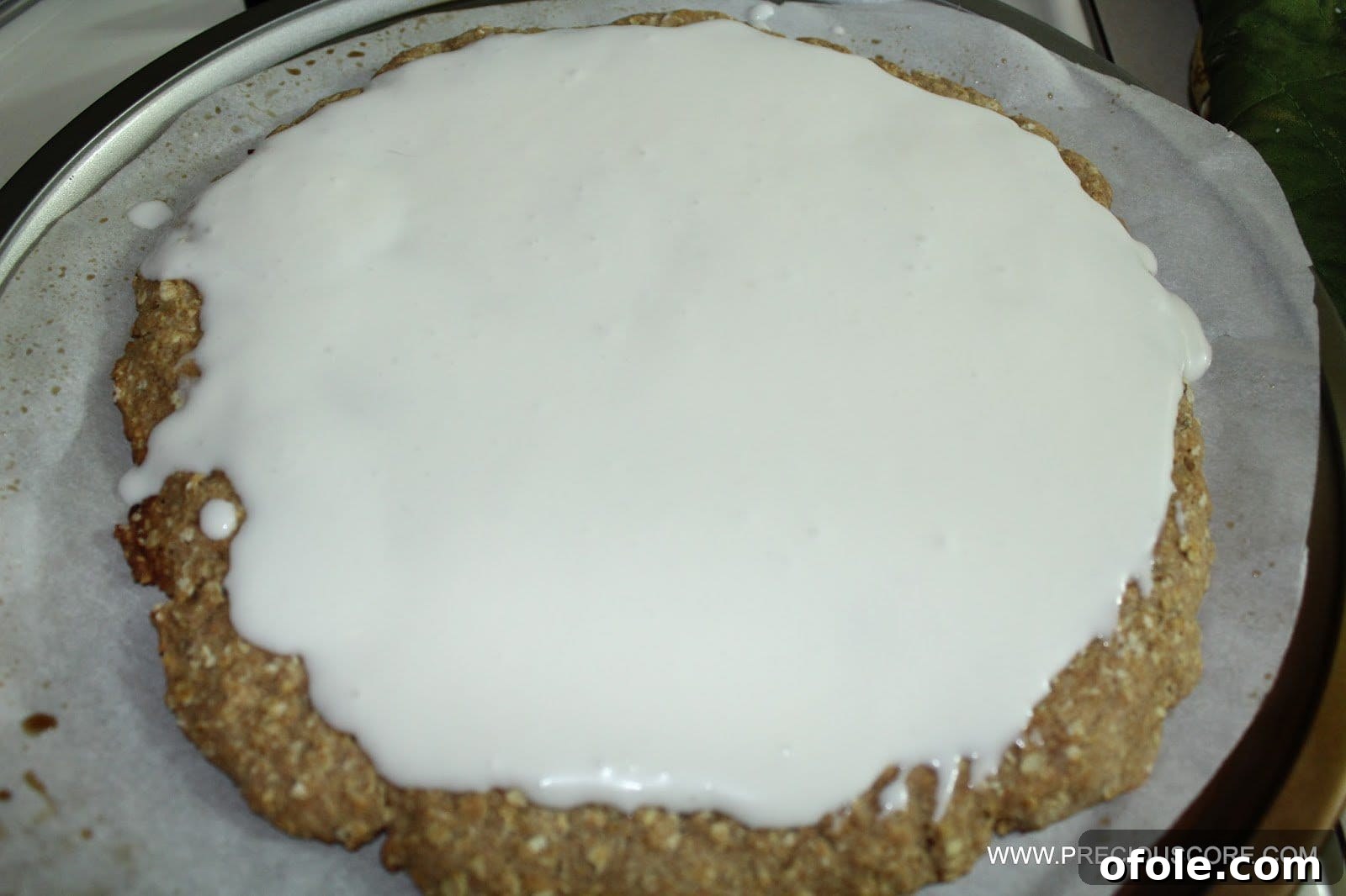 Spreading coconut cream sauce on baked fruit pizza crust
